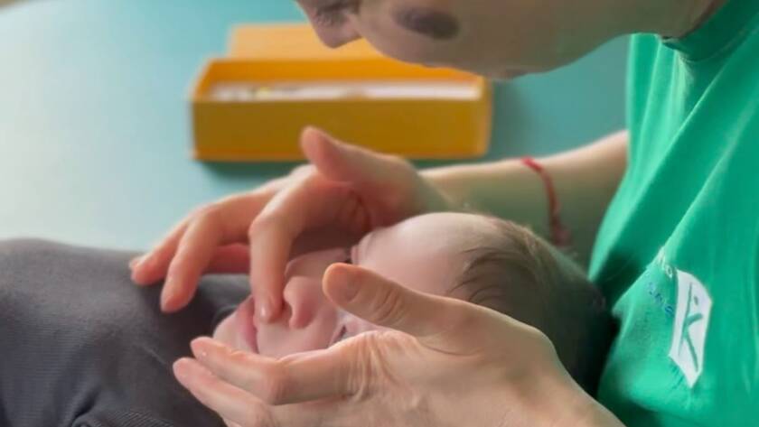 Terapeut aplicând tehnici de masaj orofacial la bebeluș